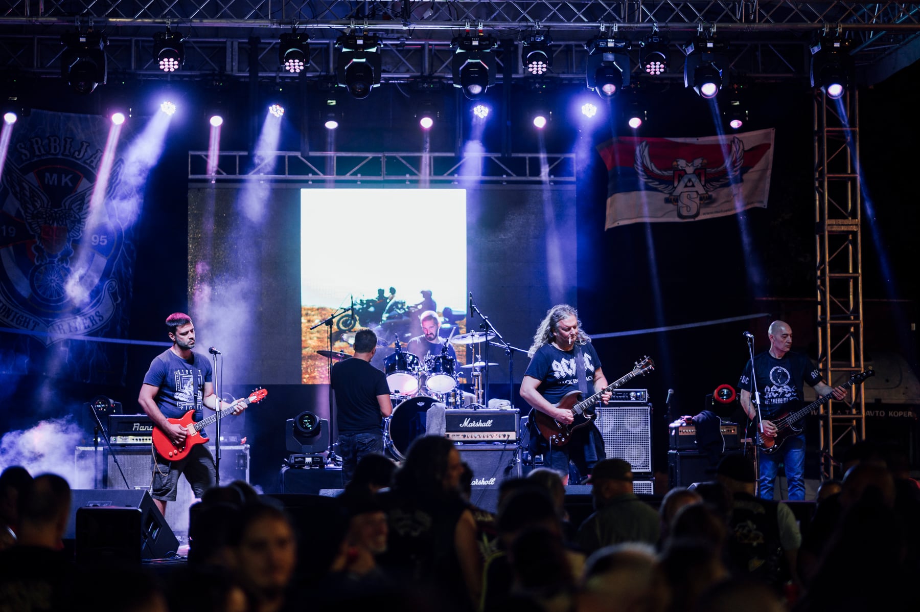 A live outdoor concert with colorful stage lights and an audience on 12 July 2025.