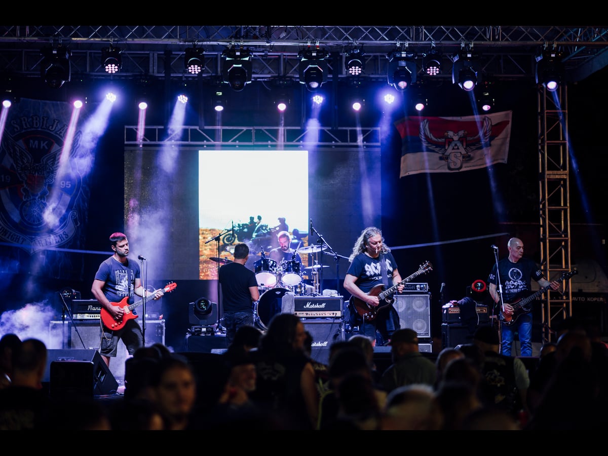 A live outdoor concert with colorful stage lights and an audience on 12 July 2025.