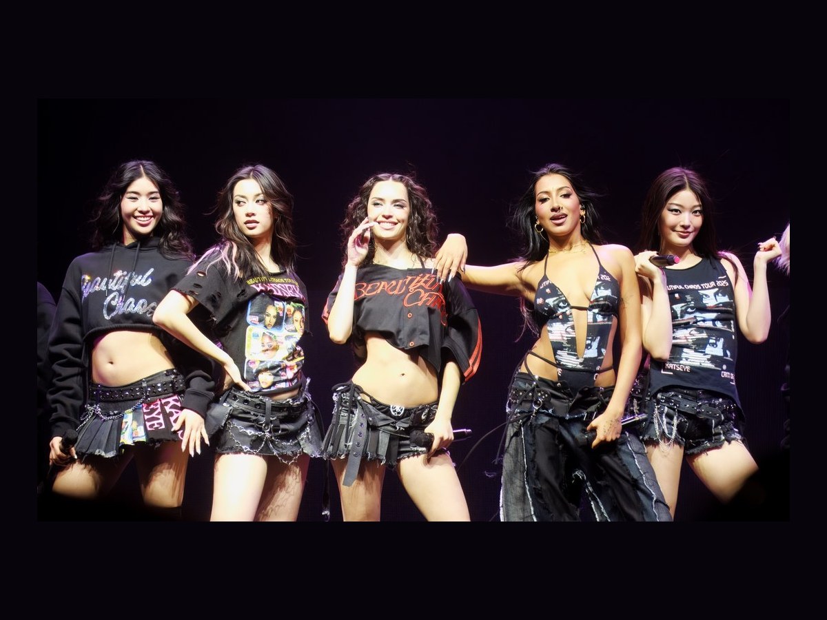 KATSEYE members on stage in Seattle on 9 December 2025.